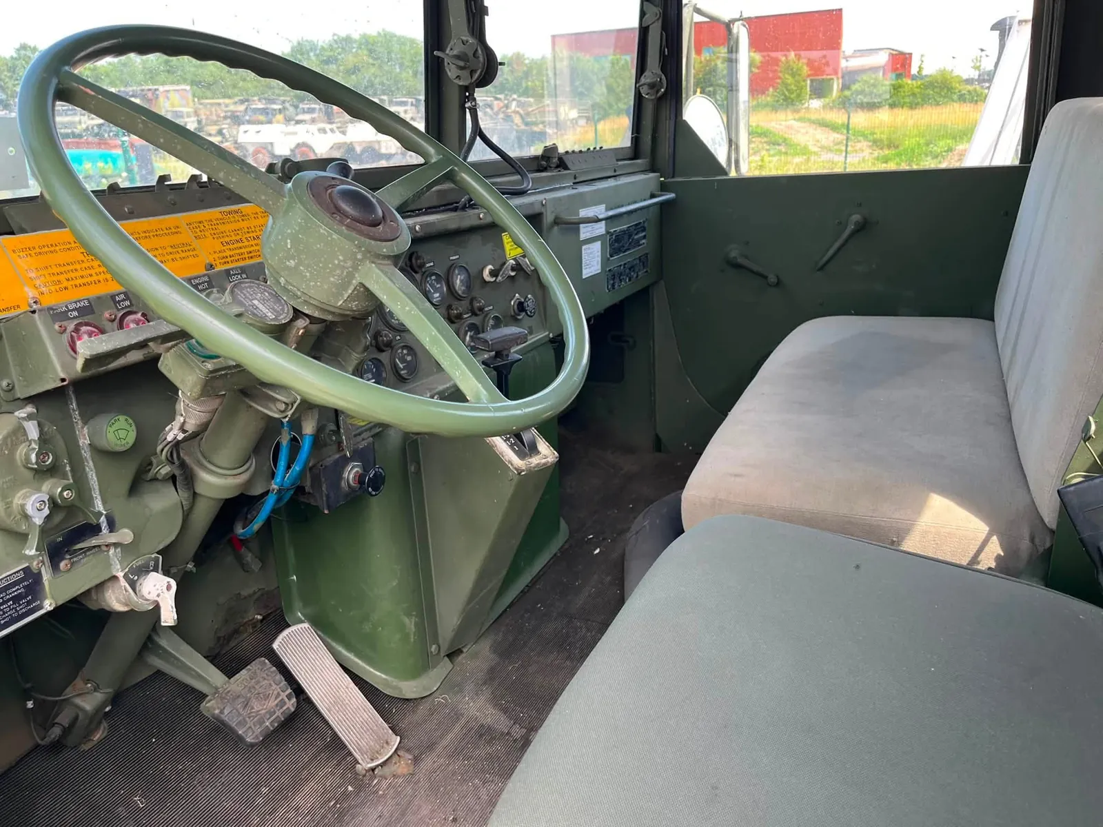 Cabine du M931 : grand volant vert, tableau de bord et banquette passager