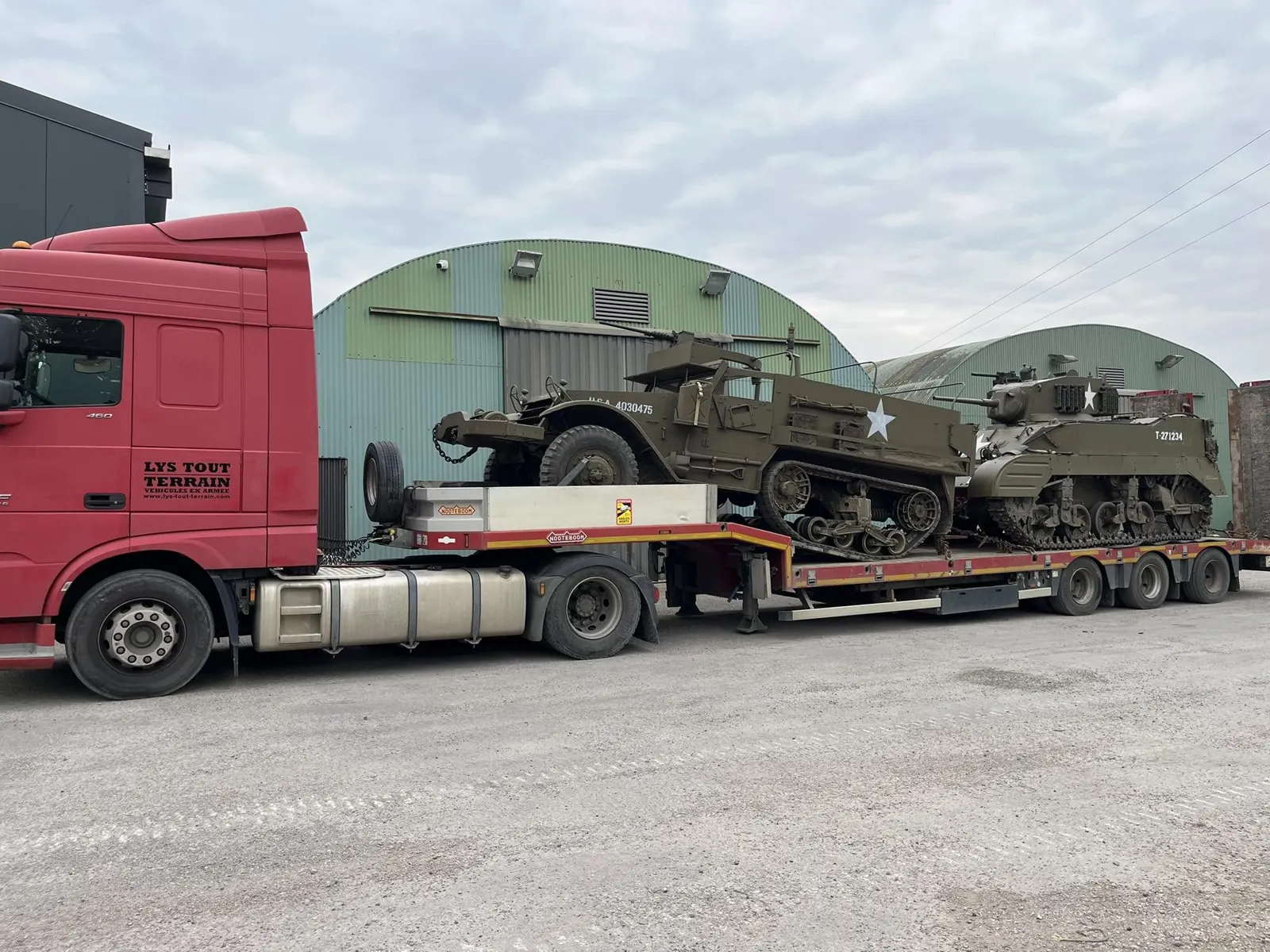 Half-track et char léger américains sur un porte-engins devant les hangars de Thérouanne