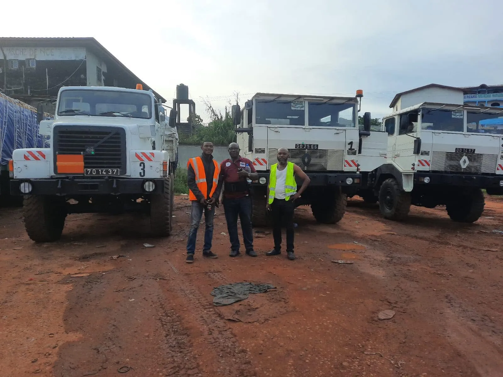 Un Volvo N10 et deux Renault TRM 10000 blancs sur un terrain de terre rouge au Congo
