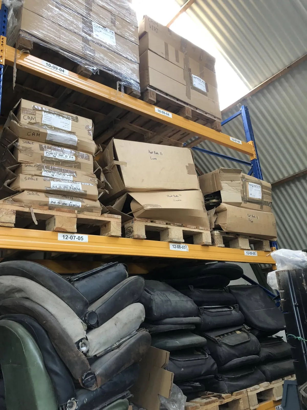 Racks du magasin : cartons de portes de P4 étiquetés par teinte, sièges empilés en dessous